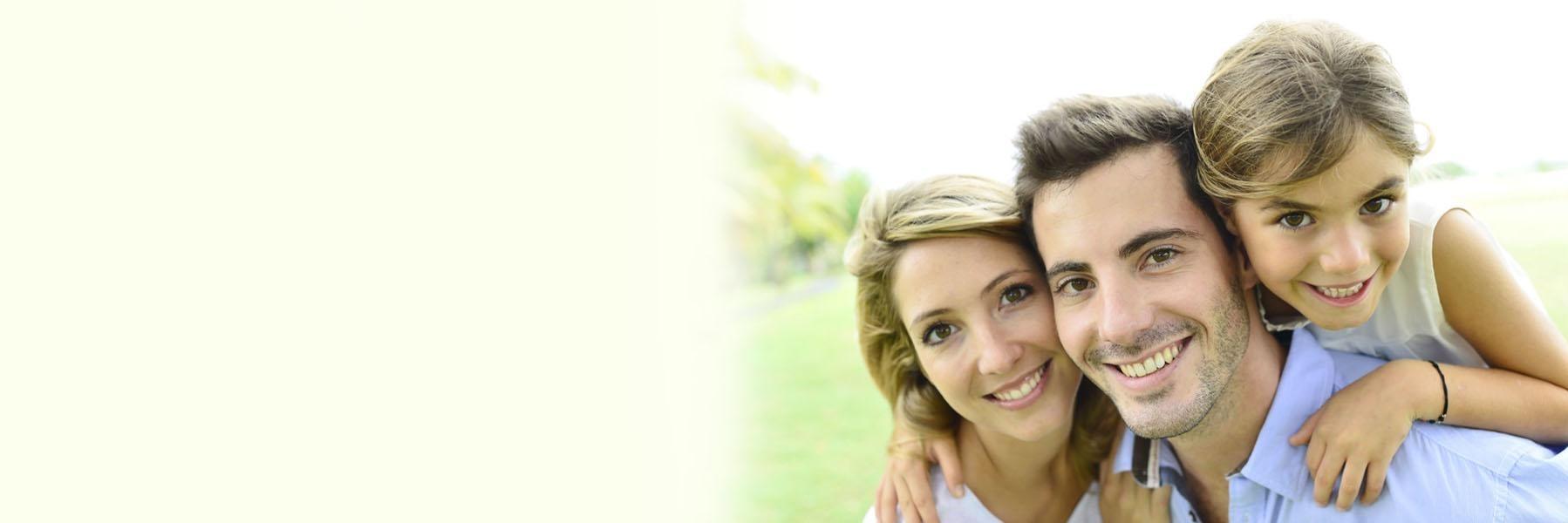 Family of dental patients smiling at Willmore Park in St Louis MO