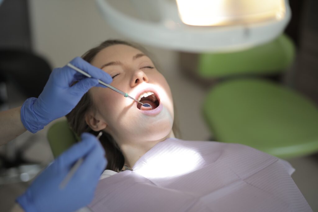 Dentist examining an older dental filling during a routine dental checkup.